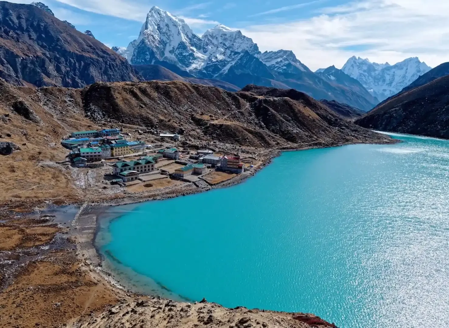 The vibrant blue lake, surrounded by rugged terrain and snow-capped peaks, makes it one of the most breathtaking destinations for trekkers